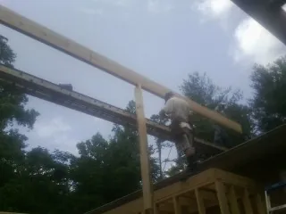 Carpenter setting a ridge beam over a new addition frame — Ice Dam Removal by Roofing Brothers in Cassoday