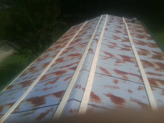 Rusted metal roof panels with new wood purlins before replacement — Storm Damage Roof Repair in Cassoday by Roofing Brothers