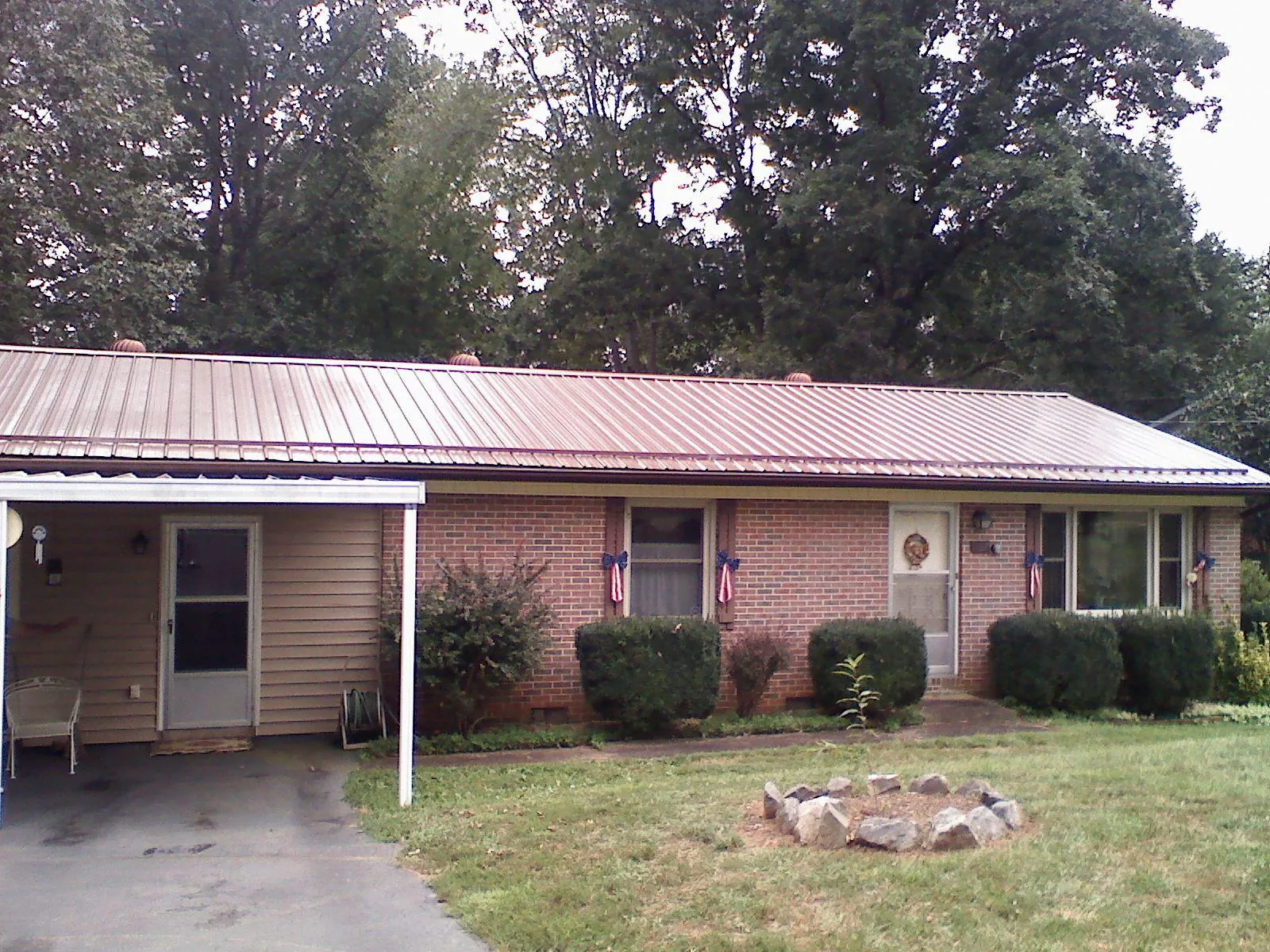 Bronze metal roof and carport on a brick ranch home — Roof Repair work by our crew in Cassoday