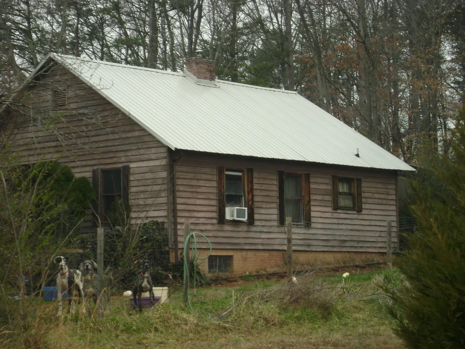 White metal roof on an old wood sided farmhouse, from a Asphalt Shingle Roof Repair job in Cassoday